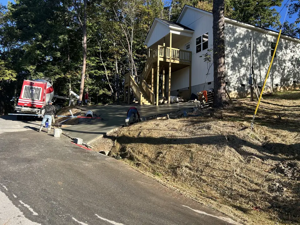 Concrete truck at a hillside lot with a new two-story home