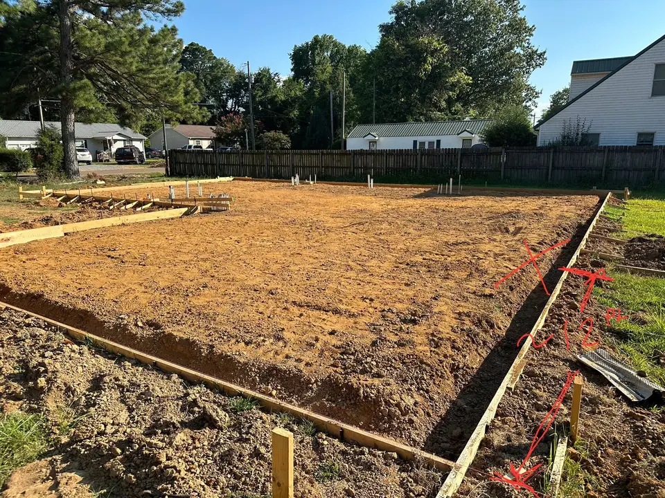 Graded building pad set inside wood forms